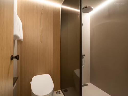 a bathroom with a toilet and a glass shower at KongGang airport hotel & free shuttle bus in Guangzhou