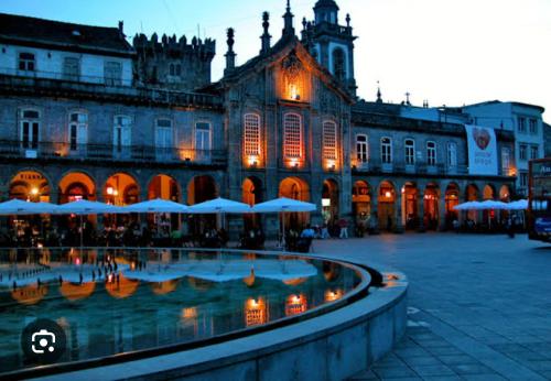 a large building with a fountain in front of it at São Marcos Apartaments in Braga