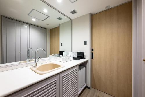 a bathroom with a sink and a large mirror at ANA Holiday Inn Iwate Kitakami by IHG in Kitakami