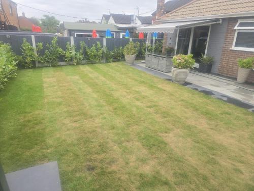 a backyard with a yard of grass and a fence at The Meadows in Market Drayton