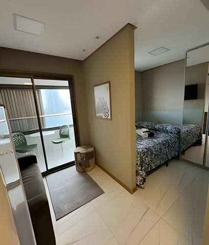 a small room with a bed and a glass door at Para quem deseja conforto e bem estar in Salvador