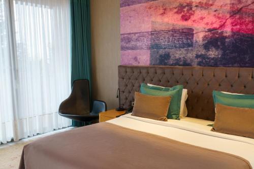 a bedroom with a large bed and a chair at Tasigo Eskisehir in Eskisehir