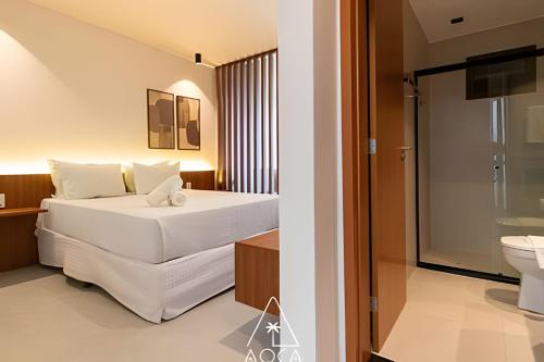 a hotel room with a bed and a bathroom at Flats Beira-Mar na Rota dos Milagres - Essence Tatuamunha in Pôrto de Pedras