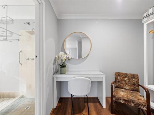 ein Badezimmer mit einem weißen Schreibtisch und einem Spiegel in der Unterkunft Leeuwin Cottage in Augusta