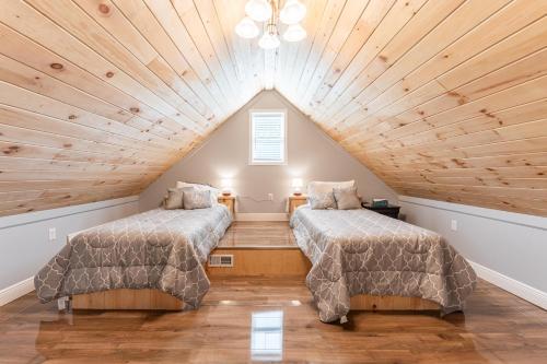 two beds in a attic room with wooden ceilings at White Fern in New Waterford