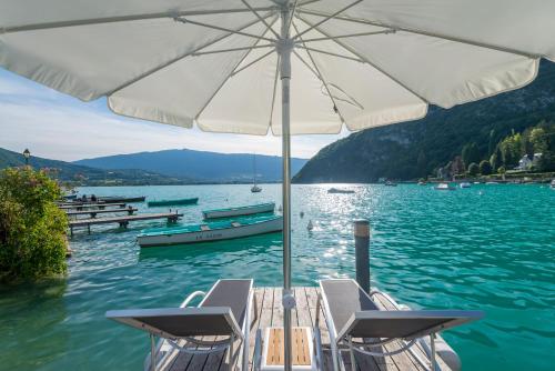 un bateau avec un parapluie sur un plan d'eau dans l'établissement Abbaye de Talloires, à Talloires