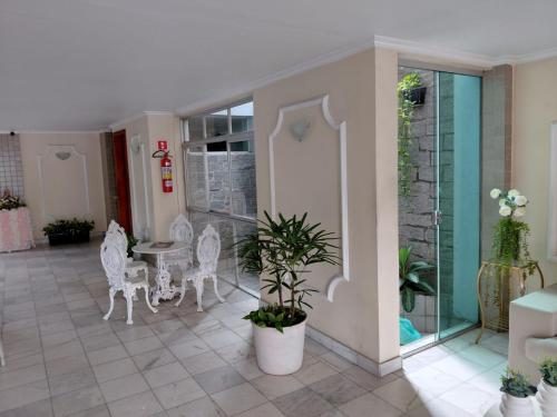 a room with white chairs and a table with a plant at Apartamento no melhor bairro de Belém Cop 30 in Belém