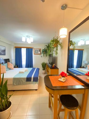 a bedroom with a bed and a table and a dining room at Executive Studio Condo Unit 2 at Marina Spatial in Piapi