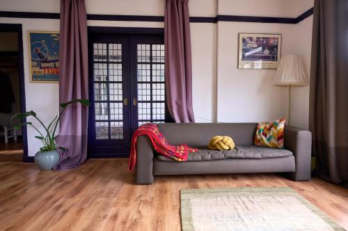 een woonkamer met een bank met een deken erop bij Olympic's Little Palace in Amsterdam