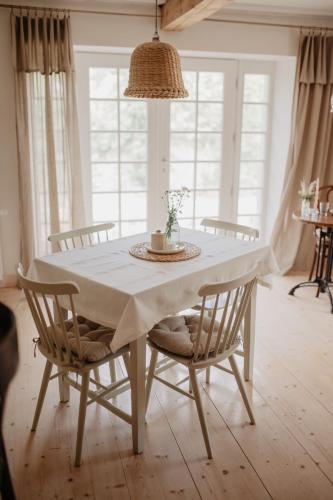 a dining room table with a white tablecloth and chairs at Sebuzínka in Ústí nad Labem