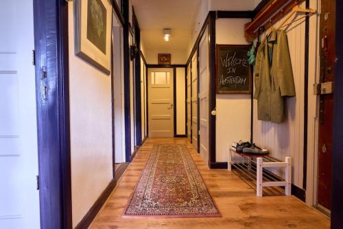 a hallway with a door and a rug on the floor at Olympic's Little Palace in Amsterdam