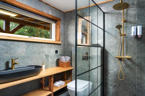 a bathroom with a shower and a toilet and a sink at Riverside Cabin - Hot Tub, Fishing and Relaxing Escape in Laugarvatn