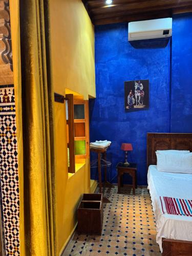 a room with a bed and a blue wall at Riad Majorelle in Rabat