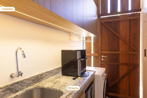 a kitchen with a counter top with a microwave at Origem Fortim - Suítes Climatizadas e Lazer in Maceio