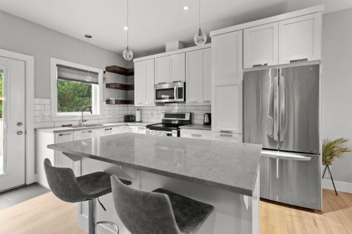 a kitchen with white cabinets and a large granite counter top at Pennywell Prestige 3BR 25BA Garage in St. John's