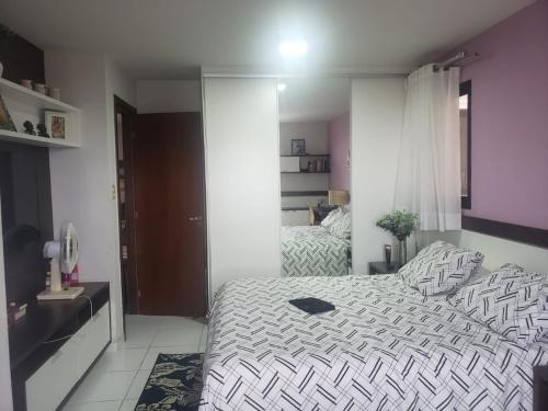 a bedroom with a bed with a black and white comforter at Apartment no Centro in Belém
