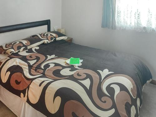 a bedroom with a bed with a black and brown blanket at Summer Time in Brundall