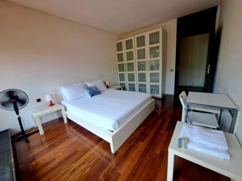 a bedroom with a white bed and a wooden floor at Lugano Centro Terrazza by Quokka 360 - In Lugano Center with parking in Lugano