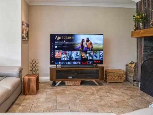 a living room with a flat screen tv on a wall at Ferndale in New Milton
