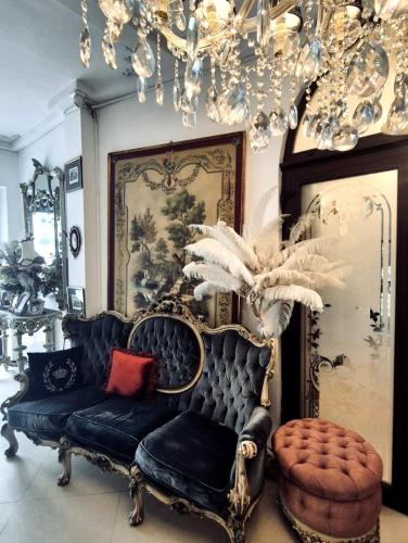 a living room with a black couch and a chandelier at Hotel Coroana Moldovei in Slănic-Moldova