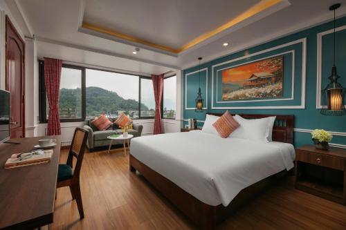 a bedroom with a large white bed and a desk and a couch at Glow Sapa Hotel in Sa Pa
