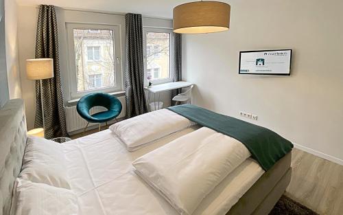 a bedroom with a bed and a blue chair at Nurban Apartments City Nürnberg in Nürnberg