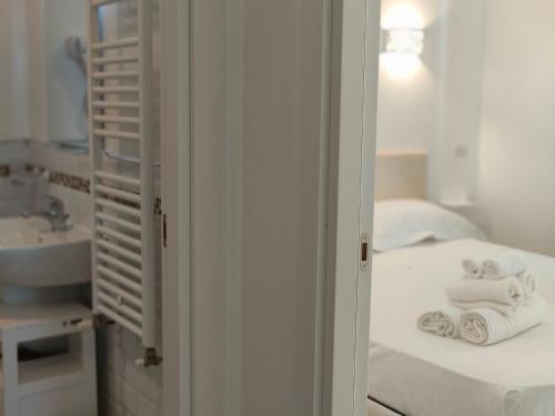 y baño con cama, lavabo y toallas. en CconfortHotels Sea Dream Palace 2, en Trani