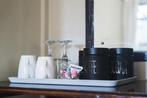 a tray with cups and other items on a table at Be My Guest Lodge in Bloubergstrand