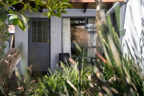 a front door of a house with a table at Be My Guest Lodge in Bloubergstrand