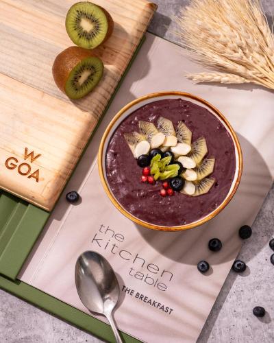 a bowl of chocolate oatmeal with fruit and a spoon at W Goa in Vagator
