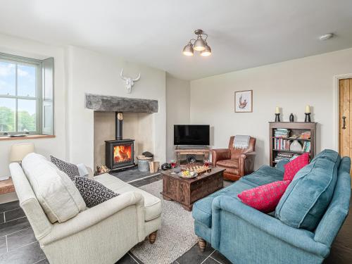 a living room with two couches and a fireplace at Coed Mawr in Betws-y-coed