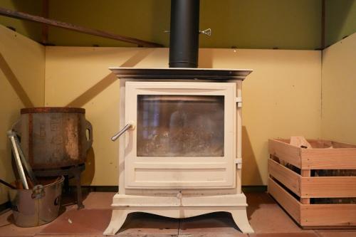 a woodburning stove in a room with a box at Base House Kinosaki お子様無料でサウナもアクティビティも楽しめる一棟貸し宿Private Japanese Villa Stay with Free Shuttle, Sauna, Activities & Kids Stay Free in Toyooka