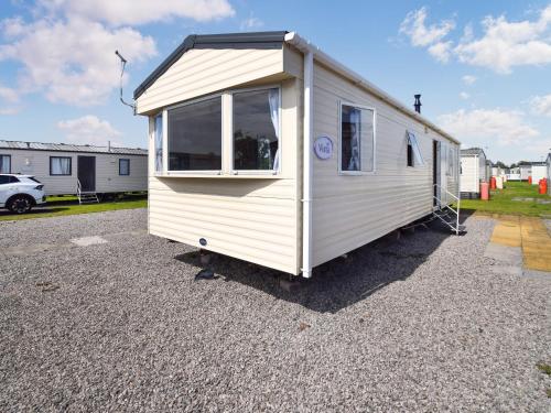 a small white trailer parked in a parking lot at J And M Retreat in Morecambe