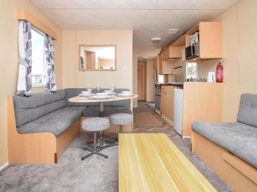a caravan living room with a table and a couch at J And M Retreat in Morecambe