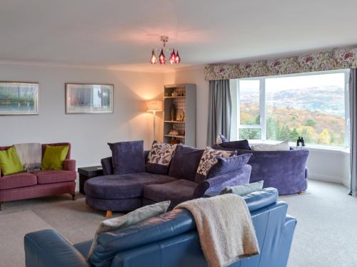 a living room with purple furniture and a large window at Devana Croft in Tarbert