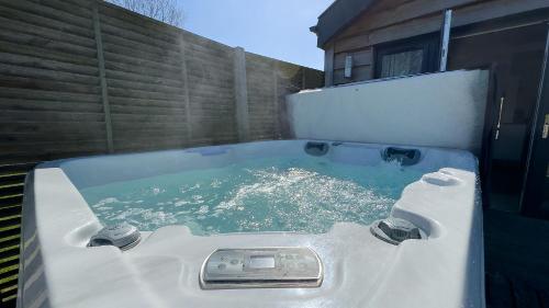 a bath tub filled with water in front of a house at The Tummel Lodge with Hot Tub in Crieff in Crieff
