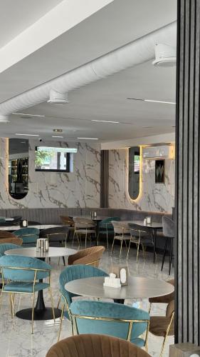 a restaurant with tables and chairs in a room at Sim Plaza Hotel in Ejmiatsin
