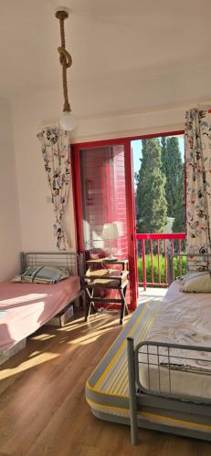 a bedroom with two beds and a balcony at Barefoot Beach House in Larnaka