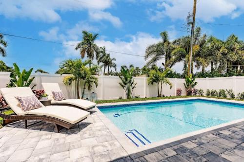 a swimming pool with chaise lounge chairs next to a fence at Luxury Naples 4br W Pool Near Vanderbilt Beach in Naples