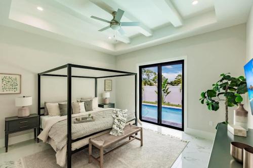 a bedroom with a bed and a ceiling fan at Luxury Naples 4br W Pool Near Vanderbilt Beach in Naples