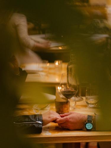 a person sitting at a table with a glass of wine at NoMad London in London