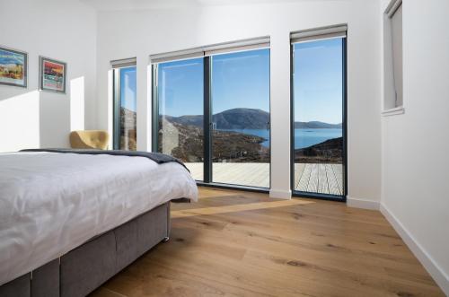 a bedroom with a bed and views of the ocean at Brandersaig 