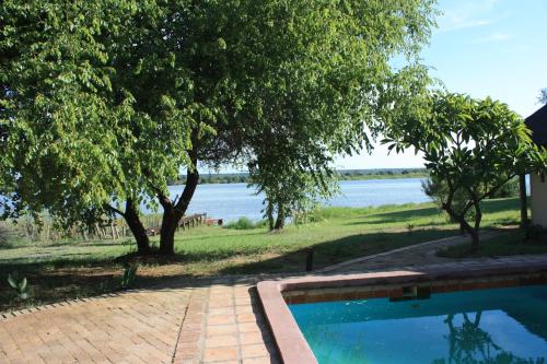 a swimming pool with a view of the water at Big 5 Toro Lodge in Kasane