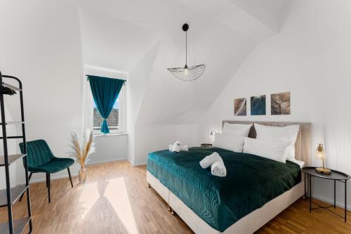 a white bedroom with a green bed and a chair at flair Alte Brauerei I Altstadt I Parkplatz I Kaffee I Highspeed WLAN I Xbox I Disney plus in Kitzingen