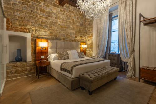 a bedroom with a large bed and a brick wall at Donati Luxury Tower Suites in Florence