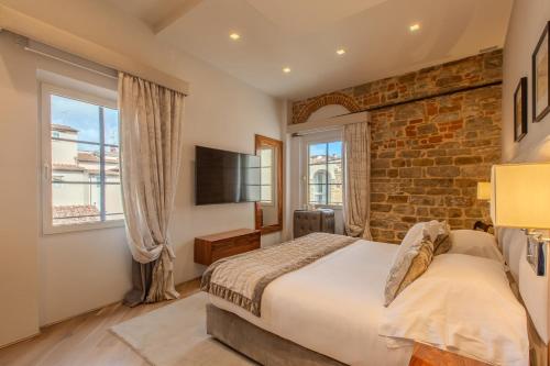 a bedroom with a bed and a brick wall at Donati Luxury Tower Suites in Florence