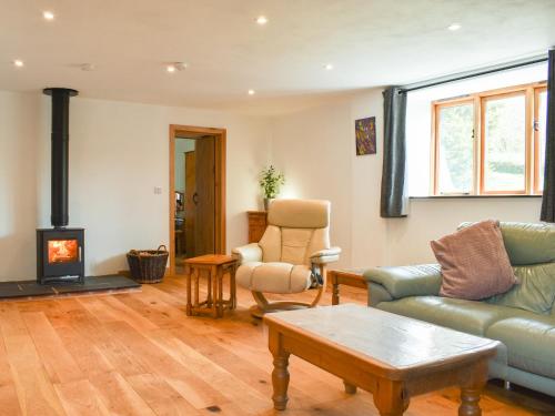 a living room with a couch and a fireplace at Slade Barn - Uk42977 in Highbray