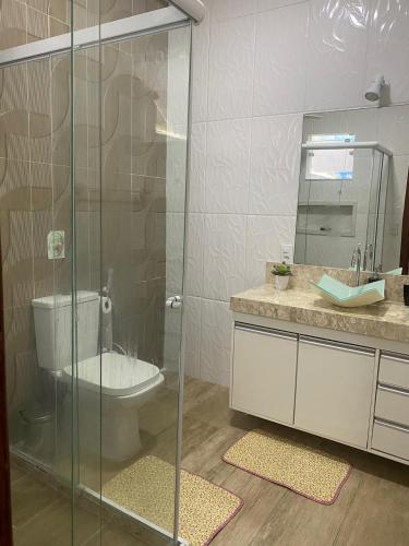 a bathroom with a toilet and a glass shower at Casa Avivada Centro in Búzios