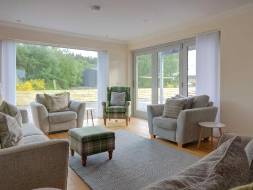 a living room with couches and chairs and a large window at Darna House in Tain