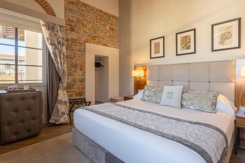a bedroom with a large bed and a brick wall at Donati Luxury Tower Suites in Florence